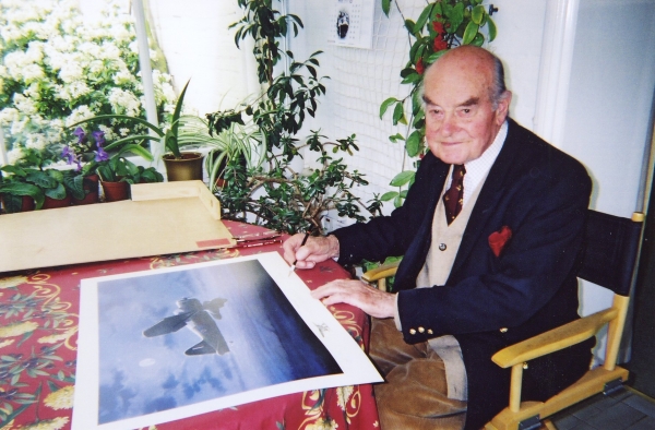 Signing the print <i>Lysander Pickup</i> by Graeme Lothian.