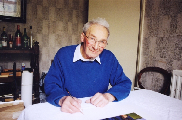 Signing the art print <i>Fighter Pilot of the RAF</i> by Graeme Lothian.