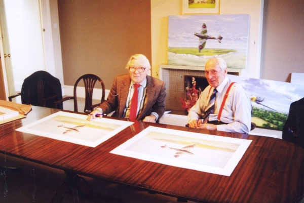 Taken at a signing event for the art print <i>Fighting Lady</i> by Graeme Lothian, the original painting of which can be seen in the background, alongside the original painting <i>Fighter General</i>, also by Graeme Lothian.